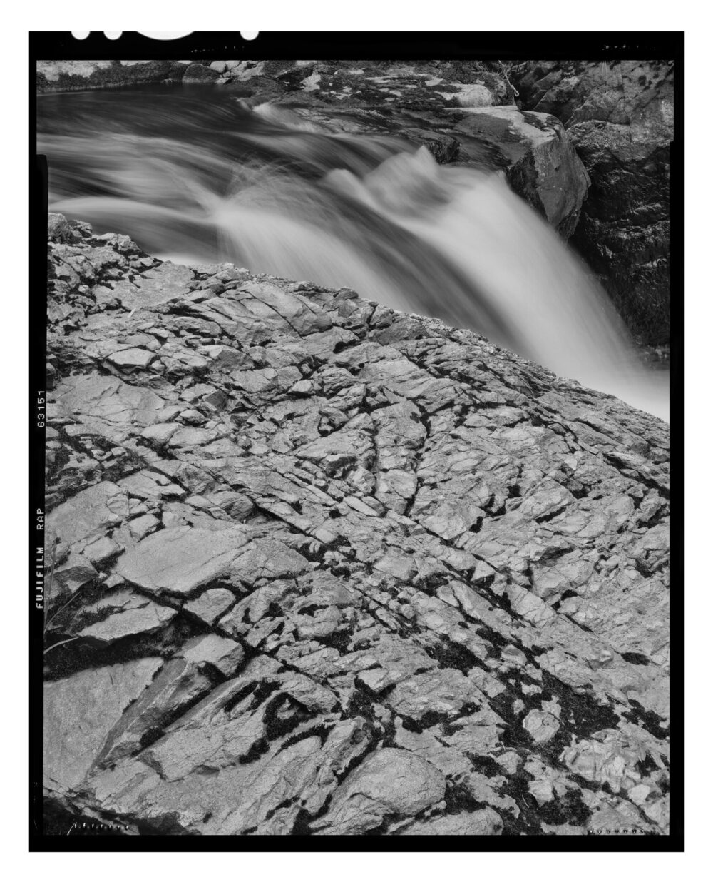black and white image of waterfall and iron ore ledge "Iron Ore Ledge and Cascades #2" is offered as a limited edition, fine art black and white photographic print. I captured this subject in 4x5 film with an Ebony 4x5 view camera and 135mm APO Rodenstock Sironar S APO lens in the Upper Peninsula of Michigan.